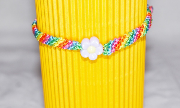 Geknüpftes Armband in Regenbogenfarben und Blume